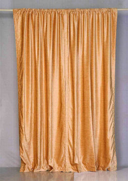 Peach velvet rod pocket curtains hung at a window