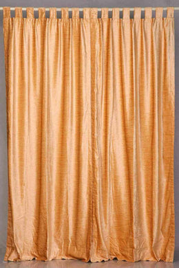 Peach velvet tab top curtains hung at a window