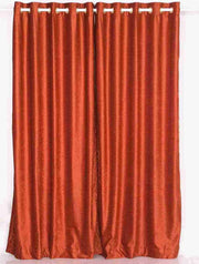 Rust velvet grommet top curtains hung at a window