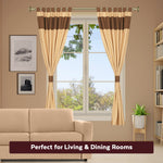 Brown raw silk tab top curtains hung at a window