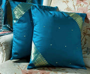 Turquoise sari cushion covers arranged on a sofa