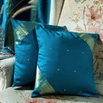Turquoise sari cushion covers arranged on a sofa