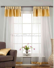 White sheer tissue tab top curtains hung at a window