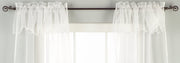 White sheer tissue rod pocket curtains hung at a window