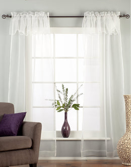White sheer tissue rod pocket curtains hung at a window