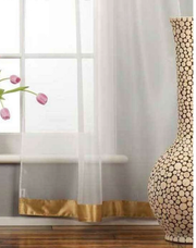 White sheer tissue tab top curtains hung at a window
