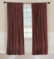 Wine velvet rod pocket curtains hung at a window