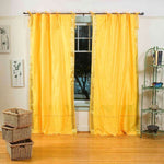 Yellow sari tie top curtains hung at a window