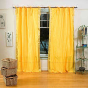 Yellow sari tie top curtains hung at a window