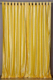 Yellow velvet tab top curtains hung at a window